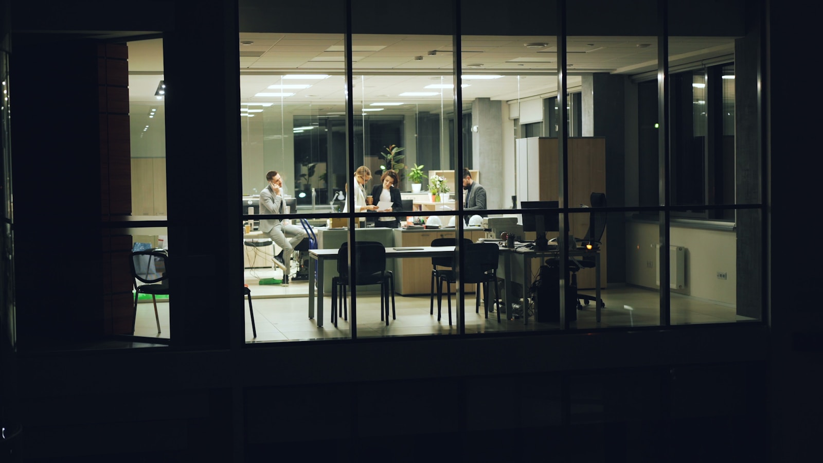 People working late in a modern office at night.